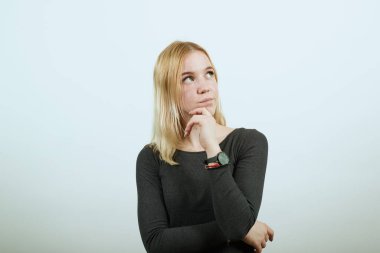 Odaklanmış kız, yüzüne karşı elini tutar ve düşünür. Akıllı İnsanlar Konsepti.