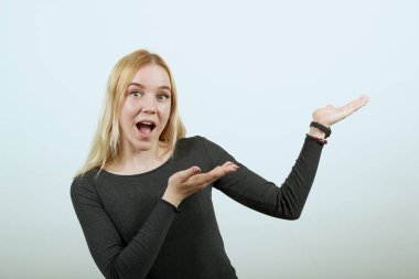 Mutlu kız gülümseyip avuç içleriyle yön gösteriyor. Amaçlı kavram