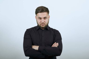 Havalı erkek kendinden emin bir şekilde ileriye bakar, ellerini göğsünden geçirir.