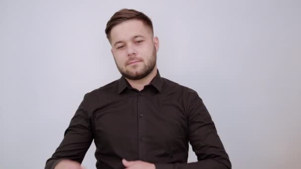 Serieuze man houdt wijsvinger in zijn gezicht en denkt — Stockvideo