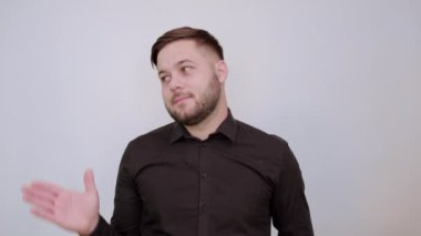 Gülümseyen, elini kaldıran, avucunu çeviren mutlu erkek. Kurnaz ve Nazik İnsanlar