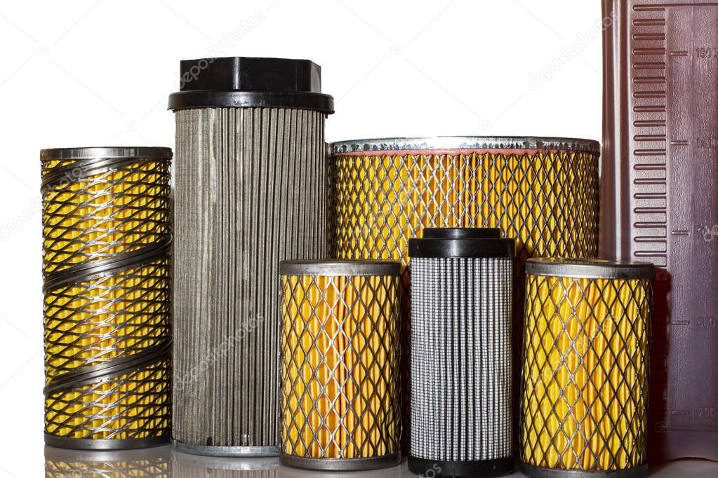 A lot of different paper and metal filters with a bottle of oil on a white background.