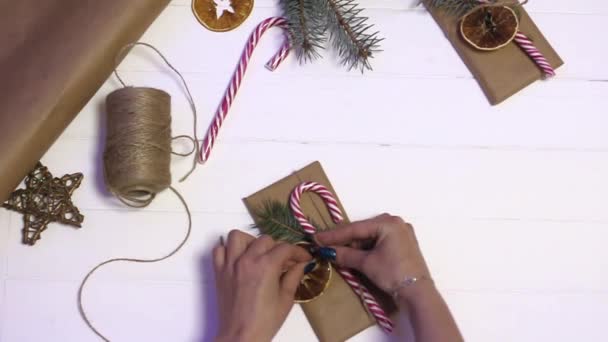 Meisje Verzamelt Een Nieuwjaarscadeau Een Houten Achtergrond — Stockvideo