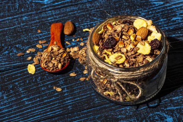 Cam bir kavanozda kurumuş meyveler ve ahşap bir arka planda tahta bir kaşık..