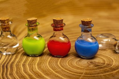 Ahşap arka planda mavi, kırmızı ve yeşil sıvılı mataralar..