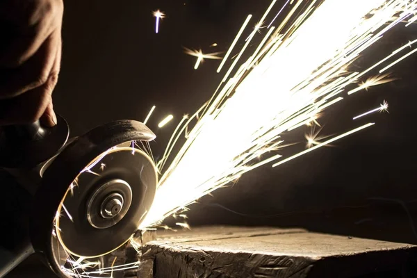 Açı öğütücü metali parlatır ve yıpratıcı tekerlekten kıvılcımlar saçar..