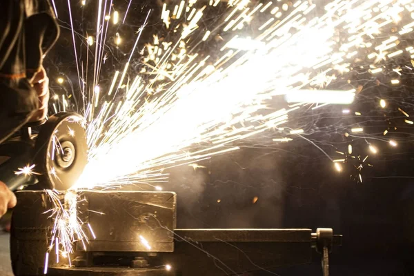 Açı öğütücü metali parlatır ve yıpratıcı tekerlekten kıvılcımlar saçar..