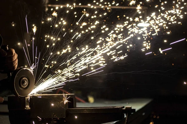 Açı öğütücü metali parlatır ve yıpratıcı tekerlekten kıvılcımlar saçar..