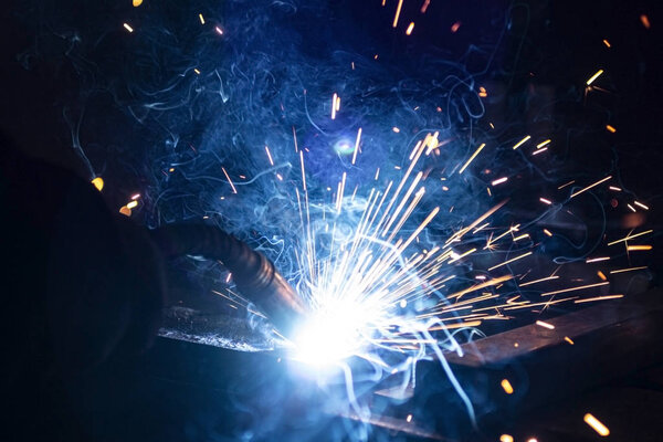 The process of welding metal in the dark with the formation of a large amount of smoke and sparks.