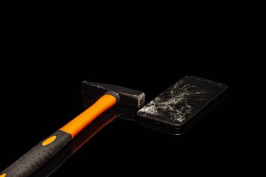 Akıllı telefon siyah arka planda çekiçle kırılmış..
