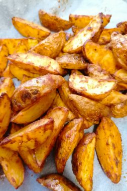 Kağıt üzerinde fırında patates dilimleri..