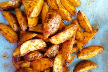 Kağıt üzerinde fırında patates dilimleri..