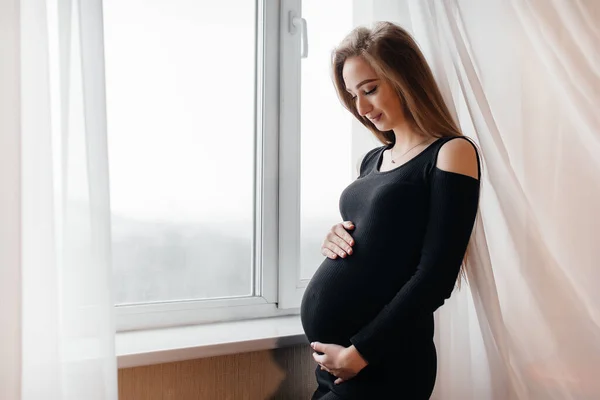 Vacker Gravid Flicka Står Ett Rum Nära Fönstret — Stockfoto