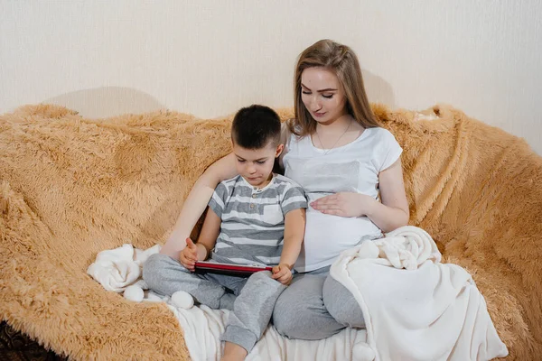 Mãe Grávida Brinca Com Filho Sofá Tablet Cuidados Família Amor — Fotografia de Stock