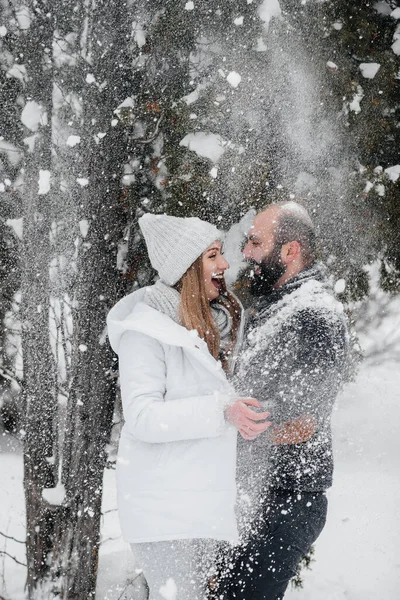 Couple playing with snow in the forest