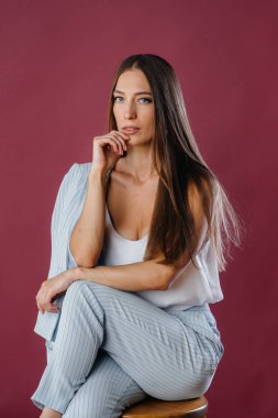 Stüdyoda sandalyede poz veren güzel seksi kız. Moda.