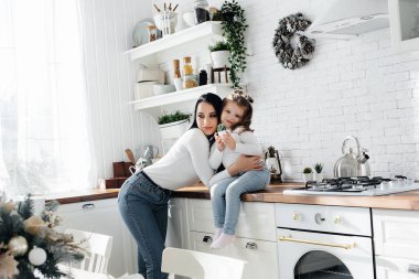 Annem ve küçük kızım mutfakta yemek pişirip oynuyorlar. Aile, mutluluk.