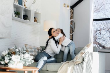 Anne ve kızları kanepede oynuyorlar. Bir aile. Mutluluk.