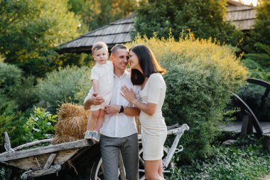 Oğulları gün batımında parkta yürüyen mutlu bir aile. Mutluluk. Aşk