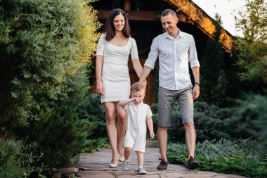 Oğulları gün batımında parkta yürüyen mutlu bir aile. Mutluluk. Aşk