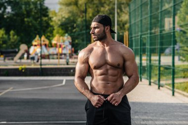 Spor sahasında üstsüz poz veren seksi fitness sporcusu. Fitness, vücut geliştirme, sağlıklı yaşam tarzı