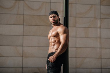 Sıcak güneşte üstsüz poz veren seksi adam. Fitness. Yaşam biçimi