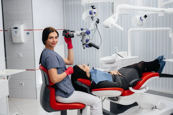 Dentysta Patrzy Przez Mikroskop Wykonuje Operację Pacjencie — Zdjęcie stockowe