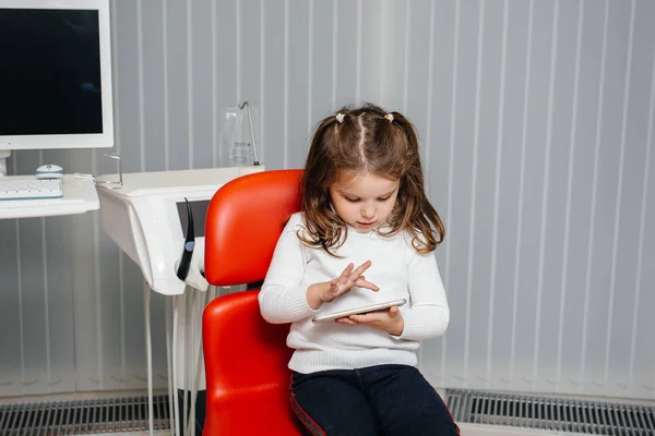 Diş Hekimliğinde Küçük Bir Kız Telefonuyla Oynar Dişçilik — Stok fotoğraf