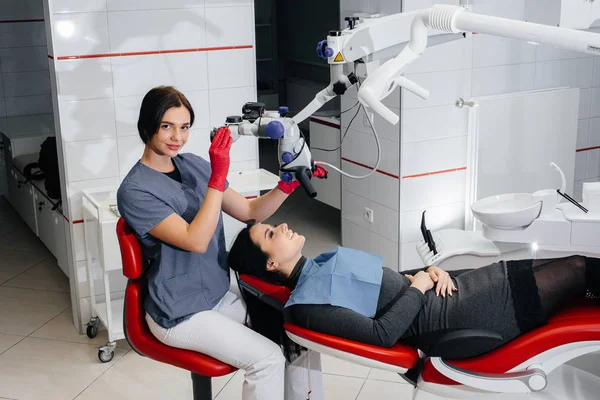 Dentista Olha Através Microscópio Realiza Uma Cirurgia Paciente — Fotografia de Stock