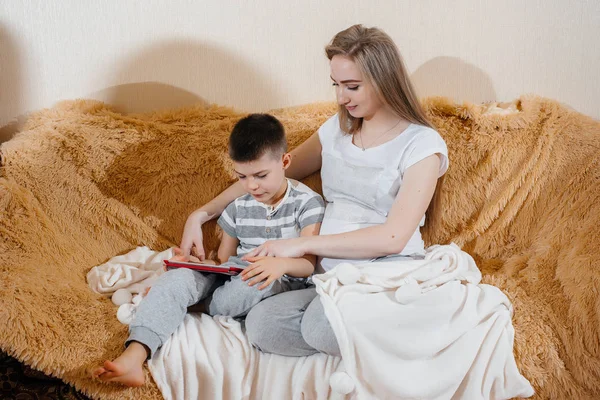 Mãe Grávida Brinca Com Filho Sofá Tablet Cuidados Família Amor — Fotografia de Stock