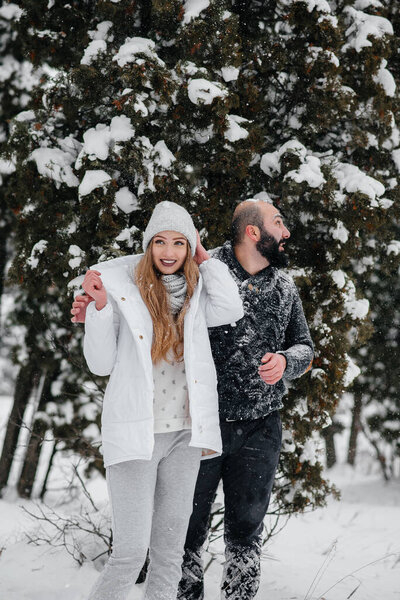 Couple playing with snow in the forest