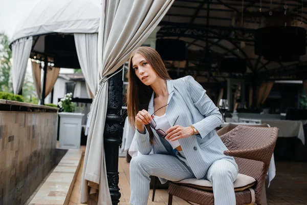 Güzel bir genç kız güzel bir evin verandasında oturuyor. Rahatlama.