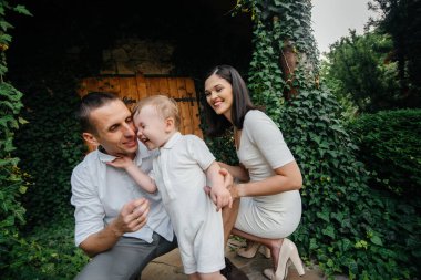 Oğulları gün batımında parkta yürüyen mutlu bir aile. Mutluluk. Aşk