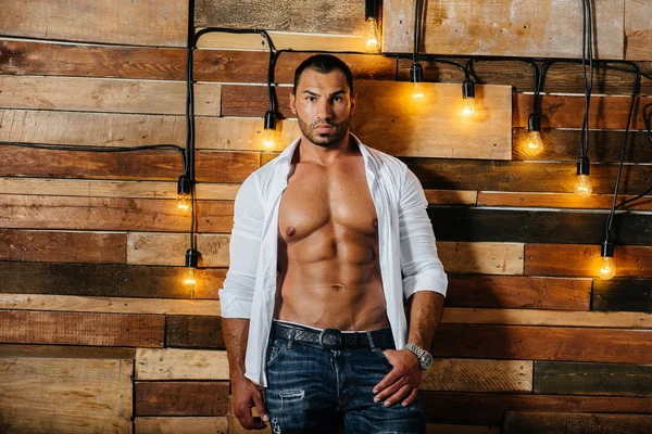 Stüdyoda üstsüz poz veren seksi bir sporcu. Fitness. Basın. Spor.