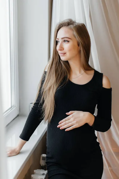Vacker Gravid Flicka Står Ett Rum Nära Fönstret — Stockfoto