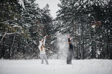Ormanda karla oynayan çift.