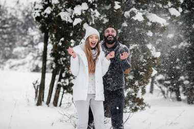 Ormanda karla oynayan çift.