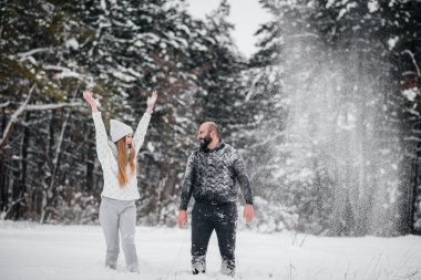 Ormanda karla oynayan çift.