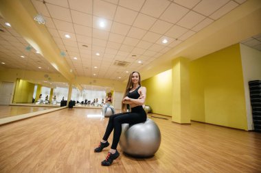 Spor salonunda grup seanslarından sonra poz veren güzel bir kız. Sağlıklı yaşam tarzı