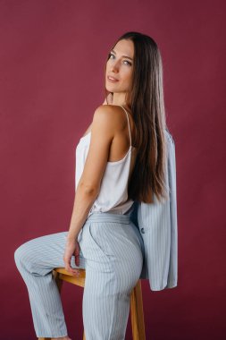 Stüdyoda sandalyede poz veren güzel seksi kız. Moda.