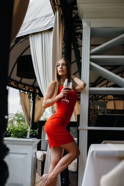 아름다운 소녀가 아름다운 베란다에서 와인을 마십니다 — 스톡 사진