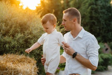 Baba ve oğul gün batımında parkta yürüyorlar. Mutluluk. Aşk