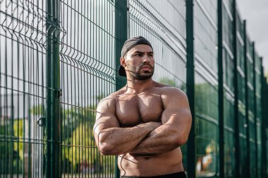 Spor sahasında üstsüz poz veren seksi fitness sporcusu. Fitness, vücut geliştirme, sağlıklı yaşam tarzı