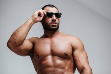 Çıplak gövdeli seksi bir sporcu gözlük takıyor. Dinlen, sağlıklı yaşam tarzı