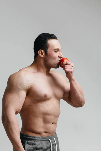 在白色背景下吃水果的性感小伙 健康饮食 — 图库照片