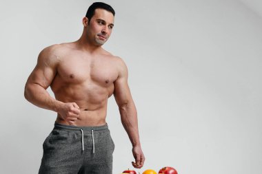 Beyaz arka planda üstsüz poz veren seksi bir sporcu. Fitness