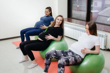 Bir grup hamile anne bir fitness kulübünde pilates ve top sporu yapıyor. Hamileyim.