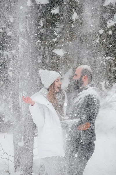 Couple playing with snow in the forest