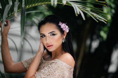 Genç ve güzel bir esmer, sık orman ve yağmur ormanları arasında poz veriyor. Spa