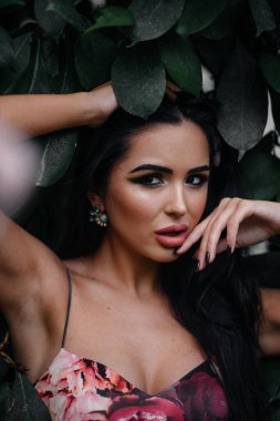 Genç ve güzel bir esmer, sık orman ve yağmur ormanları arasında poz veriyor. Spa